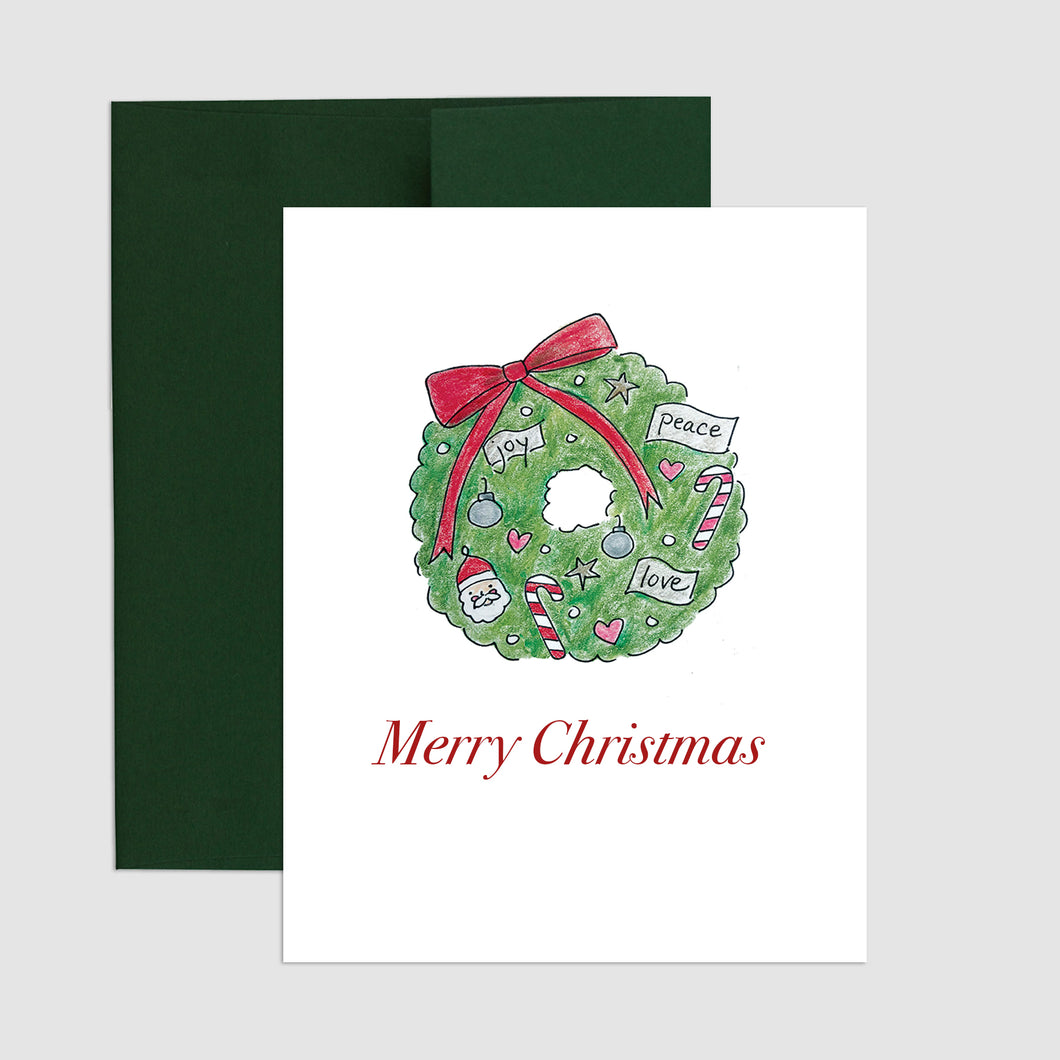 Send holiday cheer with this sweet wreath filled with Christmas ornaments. Blank interior for your own special holiday message.