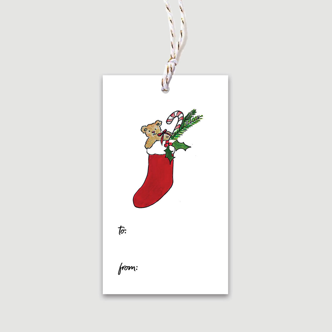 Ornament your wrapped gift with this gift tag featuring a red stocking stuffed with toys, holly and candy cane - with festive metallic ties and space to fill in 